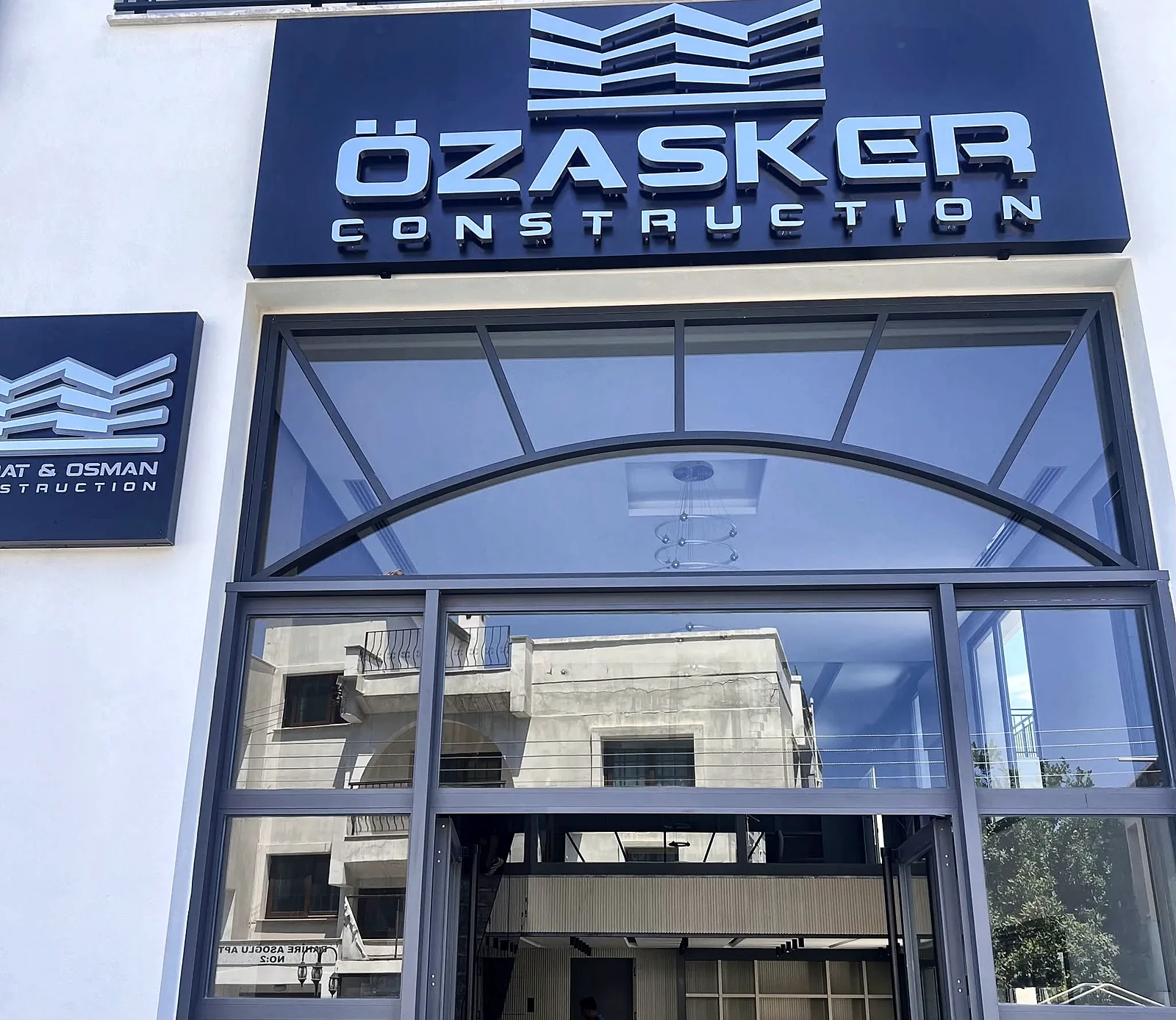 The Özasker Construction office in Kyrenia, with the company sign above the entrance